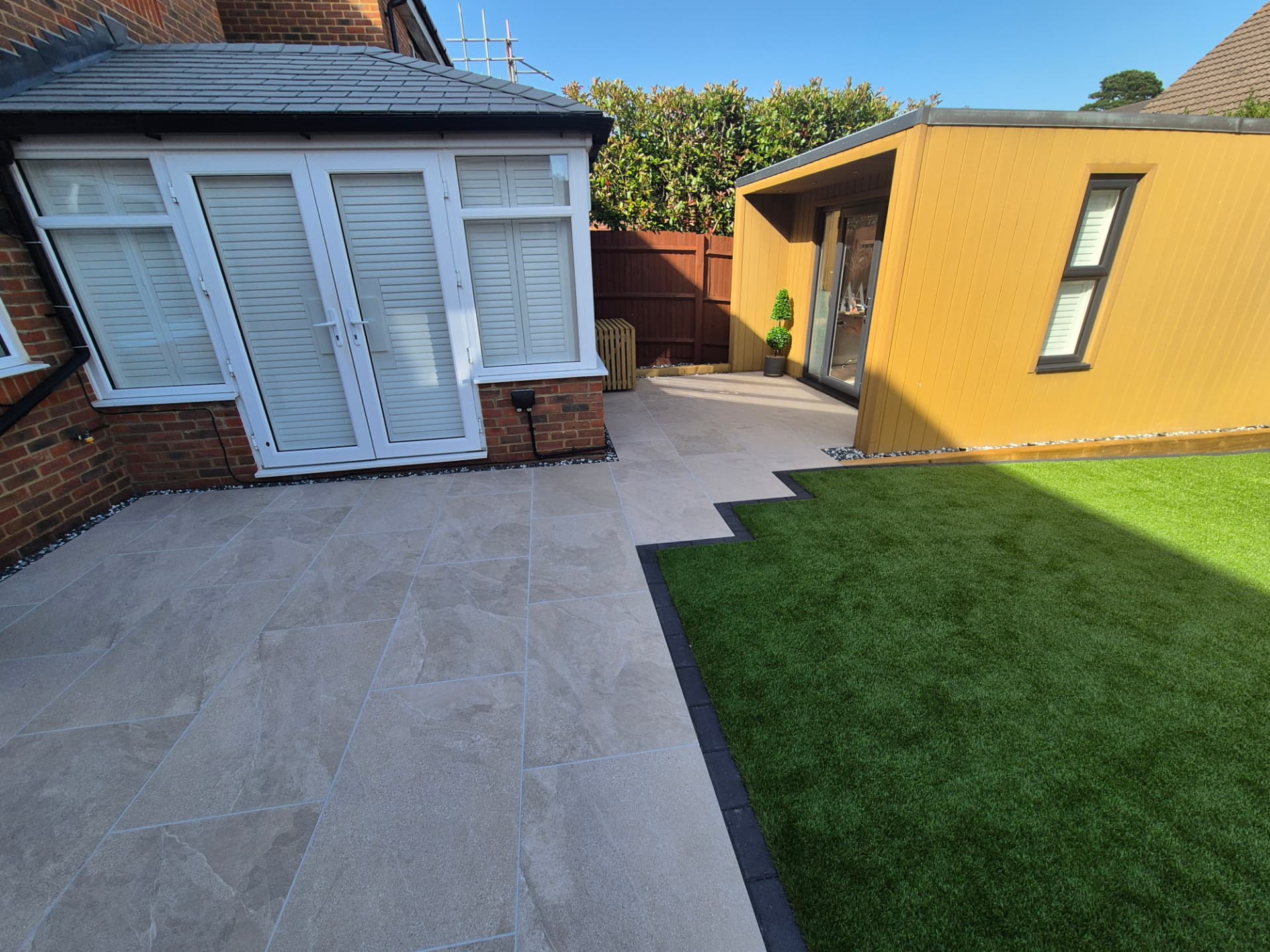Porcelain paving with artificial turf and garden room