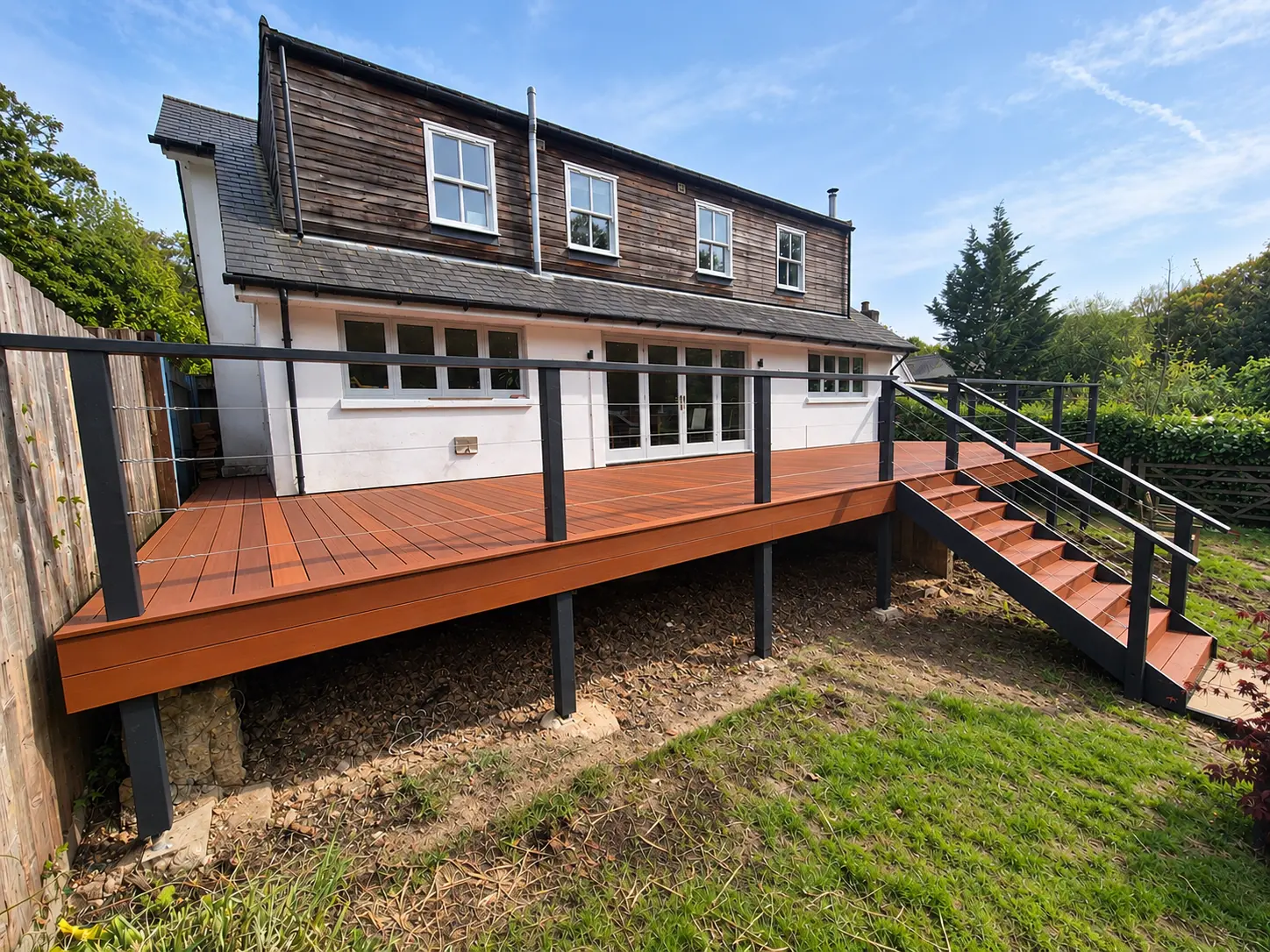 Raised timber deck with black cable railings and steps